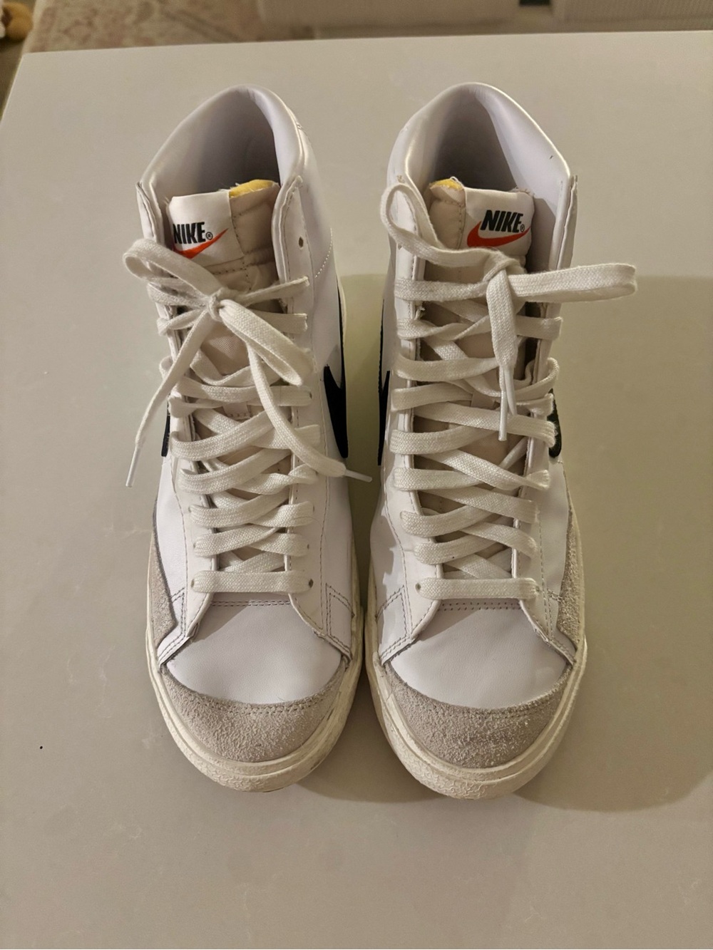 Nike White High-Top Sneakers with Black Swoosh and Orange Tongue Accent